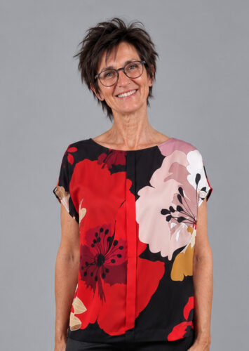 Bluse med store blomster i rød og sort, set forfra og tæt på