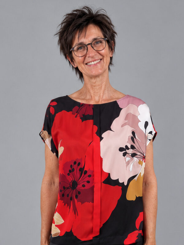 Bluse med store blomster i rød og sort, set forfra og tæt på